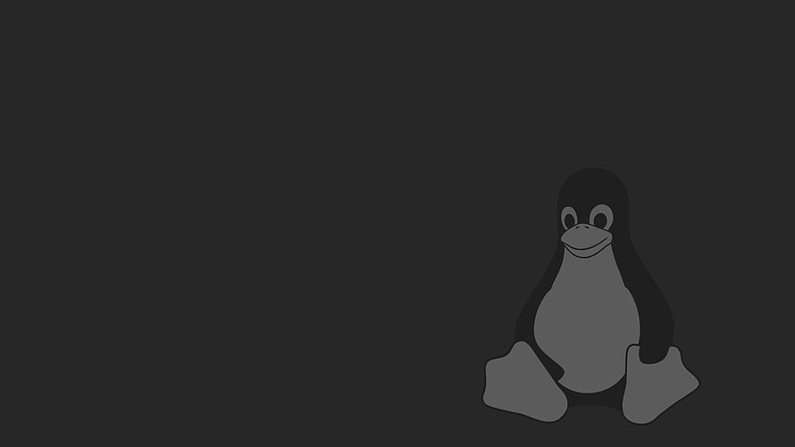 Tux the Linux Penguin Mascot Sitting on a Dark Minimalist Background HD wallpaper