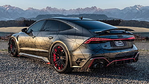 Audi RS7 Sportback with geometric livery and red brake calipers parked on gravel with mountain backdrop HD wallpaper