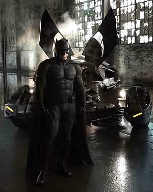 Ben Affleck as Batman Standing Before the Batmobile in a Dark Industrial Hangar HD phone wallpaper
