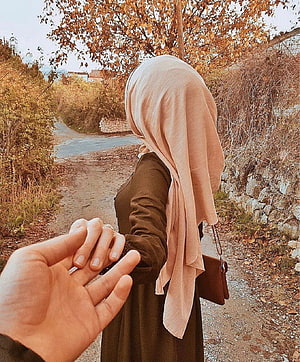 Woman in beige hijab holding hands on a rustic autumn path HD phone wallpaper