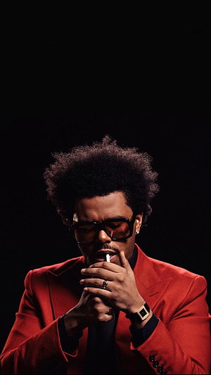 The Weeknd in a red suit and dark sunglasses smoking a cigarette against a black background HD phone wallpaper