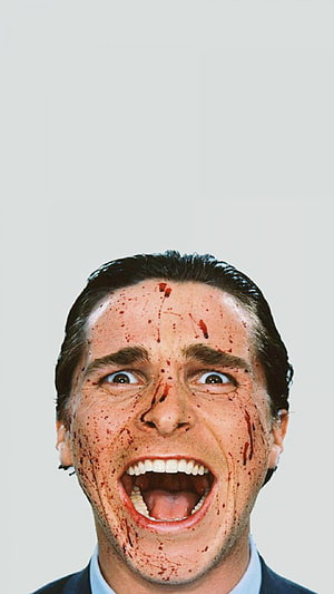Patrick Bateman from American Psycho with blood-splattered face and wide open mouth HD phone wallpaper