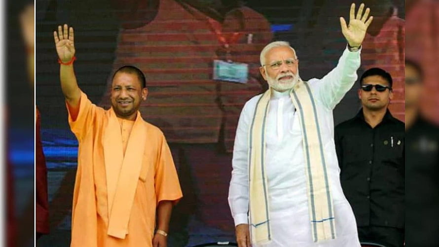 Yogi Adityanath and Narendra Modi waving to crowd at political rally HD wallpaper