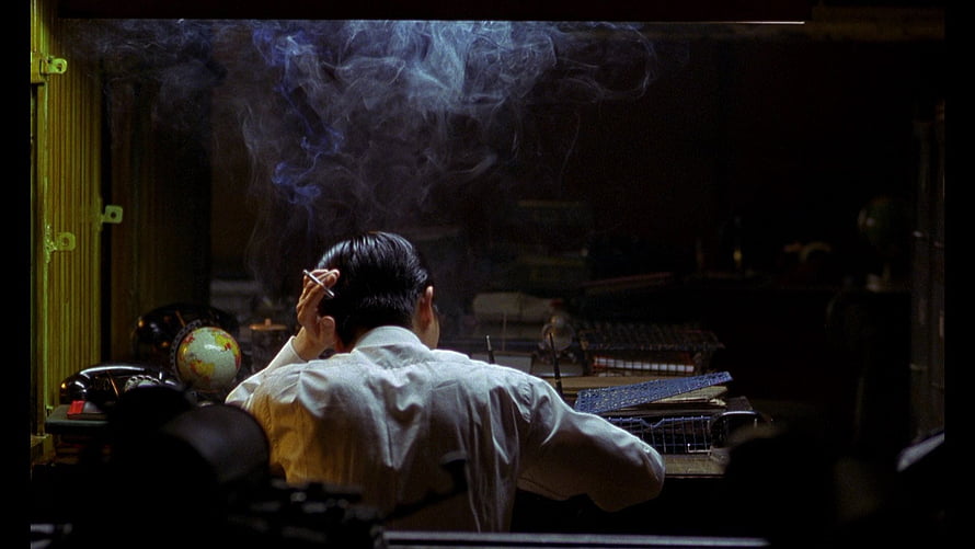 In The Mood For Love cinematic still of a man smoking in a dimly lit room HD wallpaper