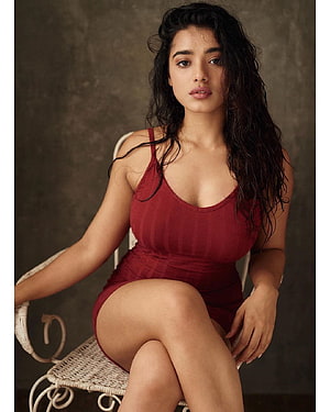 Ketika Sharma in a Fitted Burgundy Bodysuit Seated on a Wicker Chair HD phone wallpaper