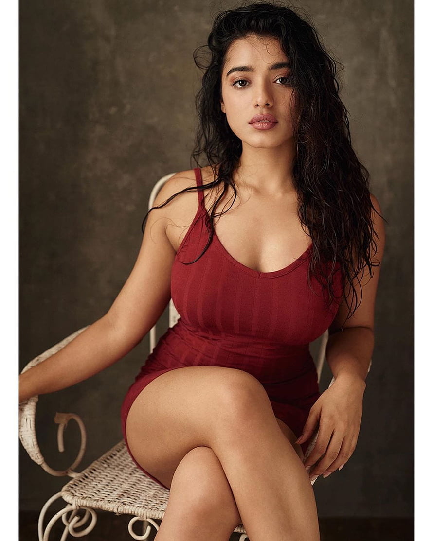 Ketika Sharma in a Fitted Burgundy Bodysuit Seated on a Wicker Chair HD phone wallpaper