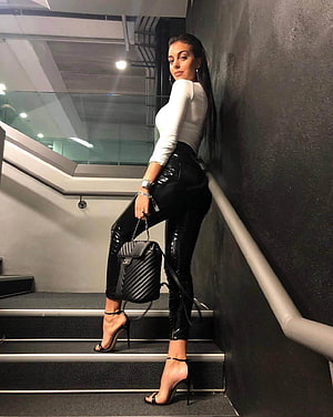 Georgina Rodriguez in White Top and Black Patent Leather Pants on Staircase HD phone wallpaper