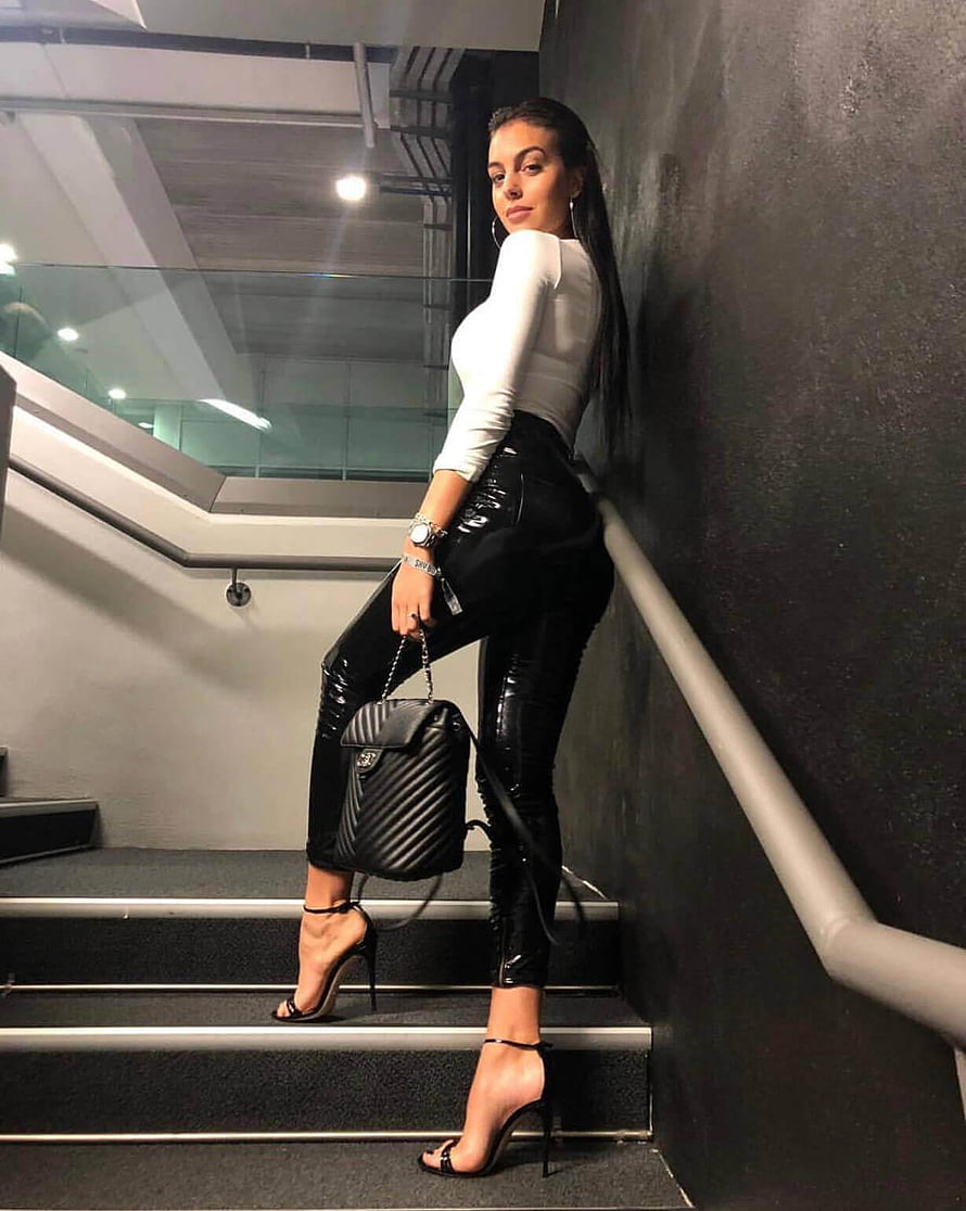 Georgina Rodriguez in White Top and Black Patent Leather Pants on Staircase HD phone wallpaper