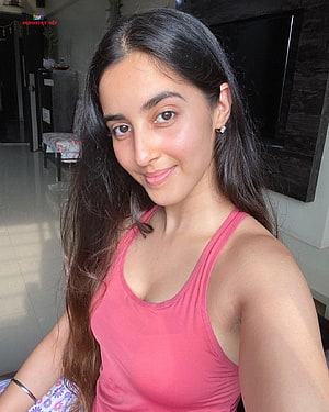 Simrat Kaur Randhawa in a pink tank top with long dark hair in a casual indoor setting HD phone wallpaper