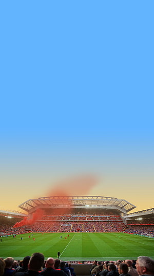Anfield Stadium at Sunset with Red Flares and Full Football Pitch HD phone wallpaper