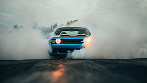 Blue Dodge Challenger SRT Hellcat performing a dramatic burnout in thick tire smoke HD wallpaper