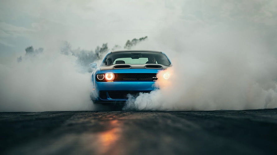 Blue Dodge Challenger SRT Hellcat performing a dramatic burnout in thick tire smoke HD wallpaper