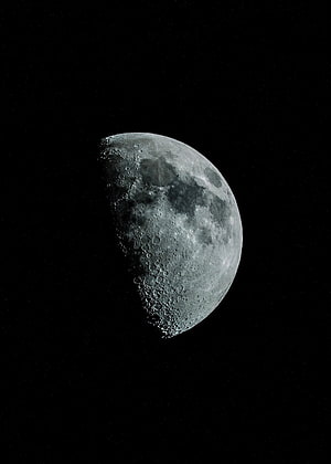Gibbous Moon with Craters and Mare Features Against a Starry Black Sky HD phone wallpaper