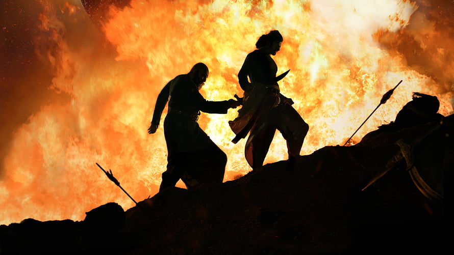 Kattappa and Bahubali Silhouetted Against Massive Fire Explosion in Epic Battle Scene HD wallpaper