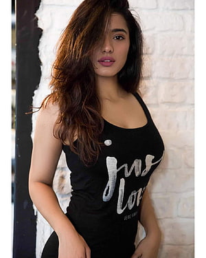 Kethika Sharma in a Black Tank Top Against a White Brick Wall HD phone wallpaper