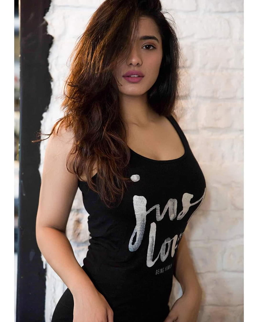 Kethika Sharma in a Black Tank Top Against a White Brick Wall HD phone wallpaper
