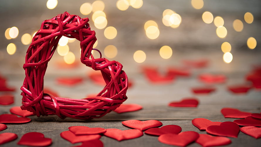 Red Woven Heart Ornament with Scattered Petals and Warm Bokeh Lights HD wallpaper