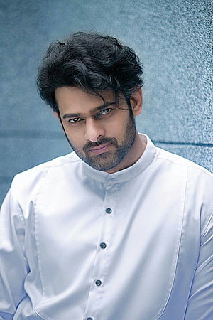 Prabhas in a white mandarin collar shirt with a textured blue background HD phone wallpaper