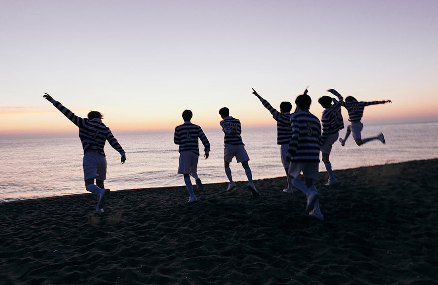 ENHYPEN Silhouetted on Beach at Sunset in Striped Jerseys HD wallpaper