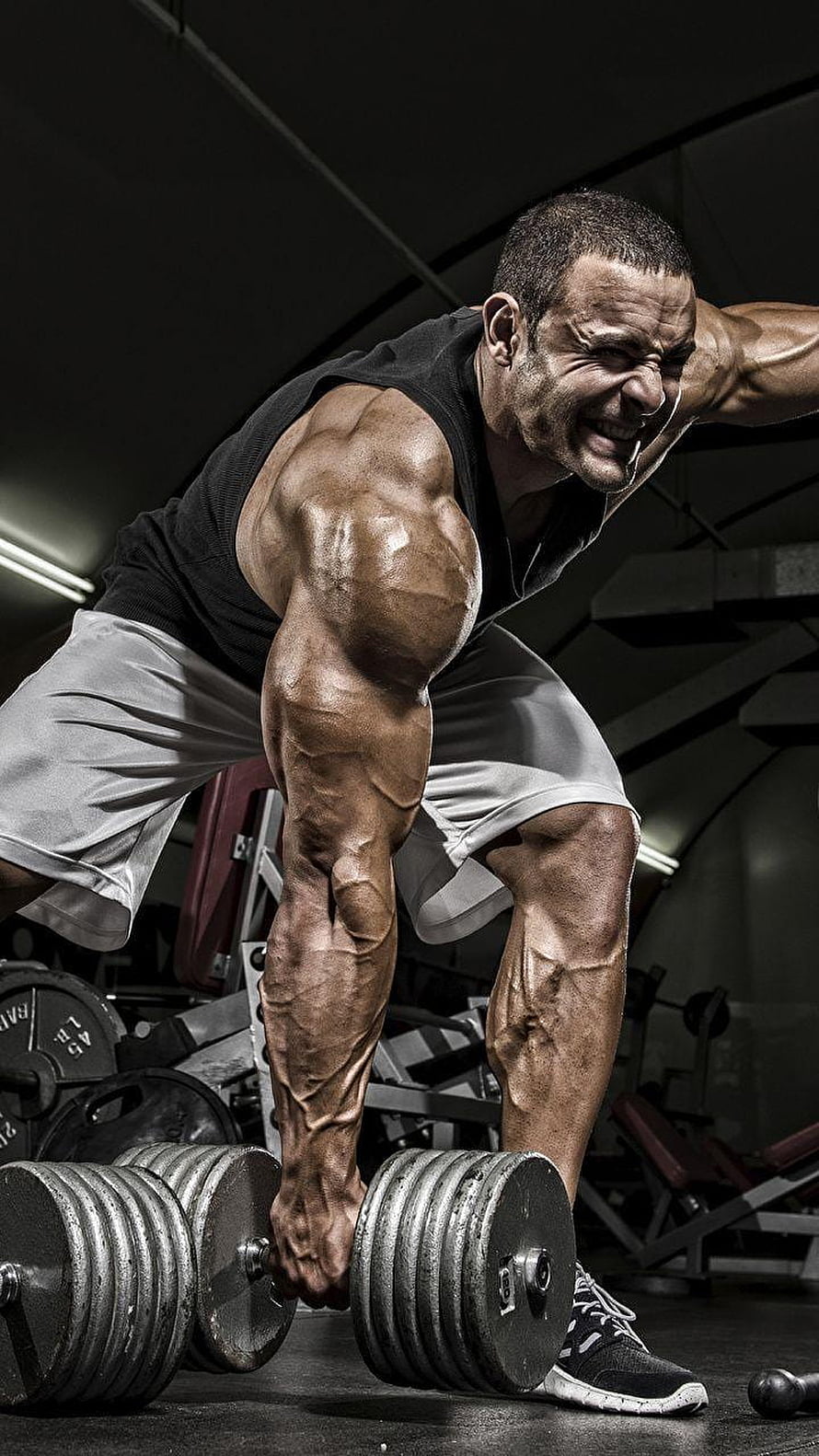 Muscular Bodybuilder Performing Heavy Dumbbell Row in Dark Gym Setting HD phone wallpaper