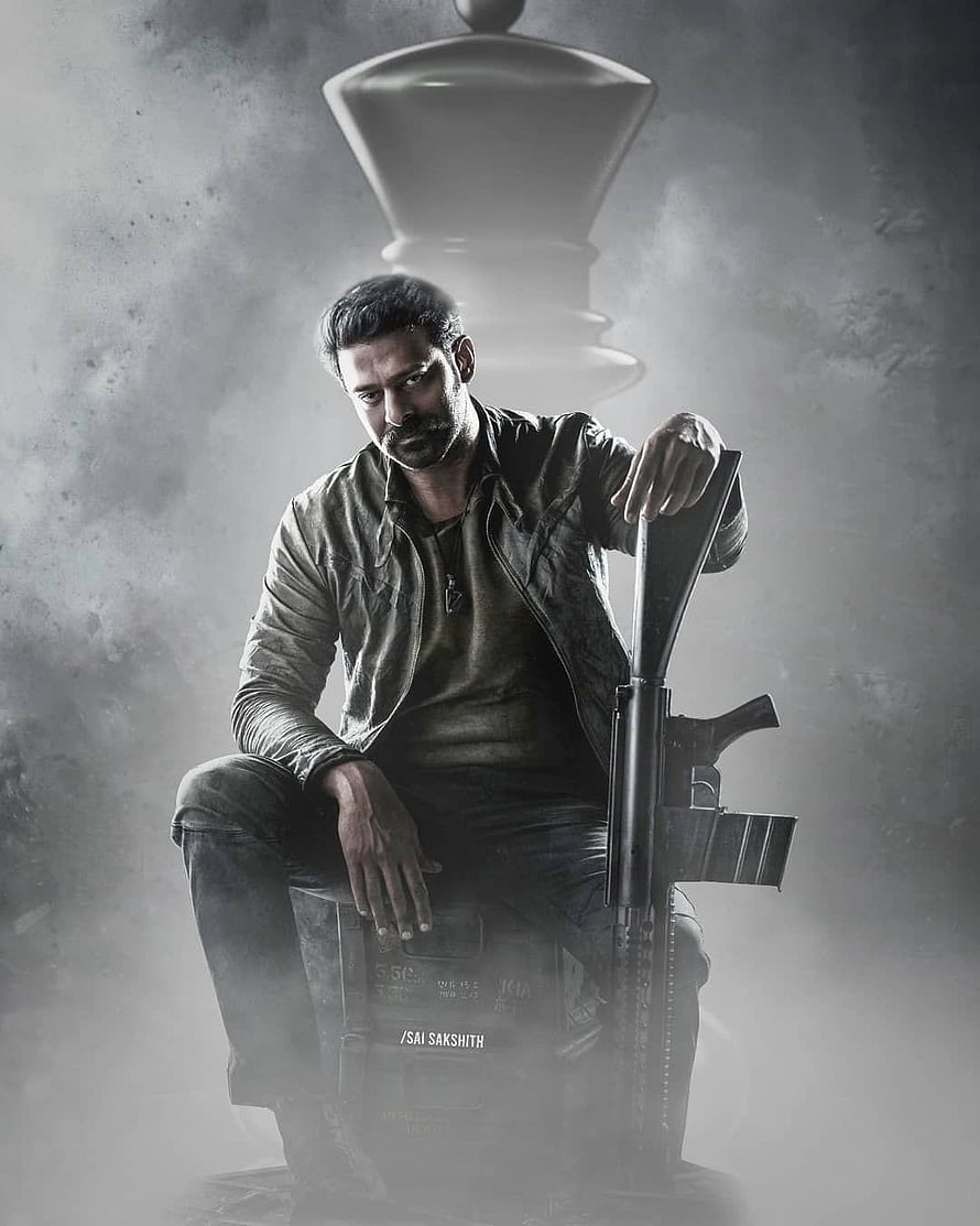 Prabhas as Salaar in a moody monochrome portrait with rifle and chess piece HD phone wallpaper