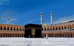 The Holy Kaaba in Mecca with Minarets and Arched Courtyard Under a Clear Blue Sky HD wallpaper