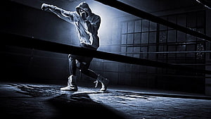 Bellator MMA Fighter in Hoodie Throwing Punch in Dark Boxing Ring HD wallpaper
