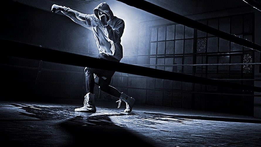 Bellator MMA Fighter in Hoodie Throwing Punch in Dark Boxing Ring HD wallpaper