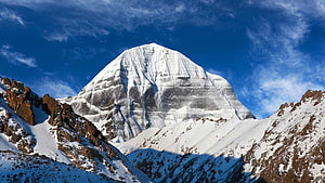 Majestic Mount Kailash Peak Rising Above Snowy Ridges Under a Deep Blue Sky HD wallpaper