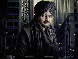 Sidhu Moose Wala Portrait in Black Turban and Scarf Against Urban Cityscape HD wallpaper