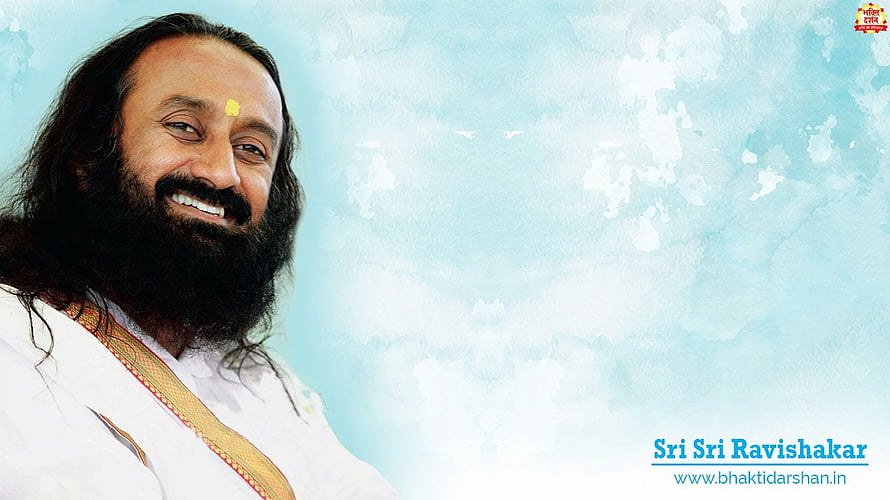 Sri Sri Ravi Shankar smiling portrait with white kurta and tilak on a soft blue background HD wallpaper