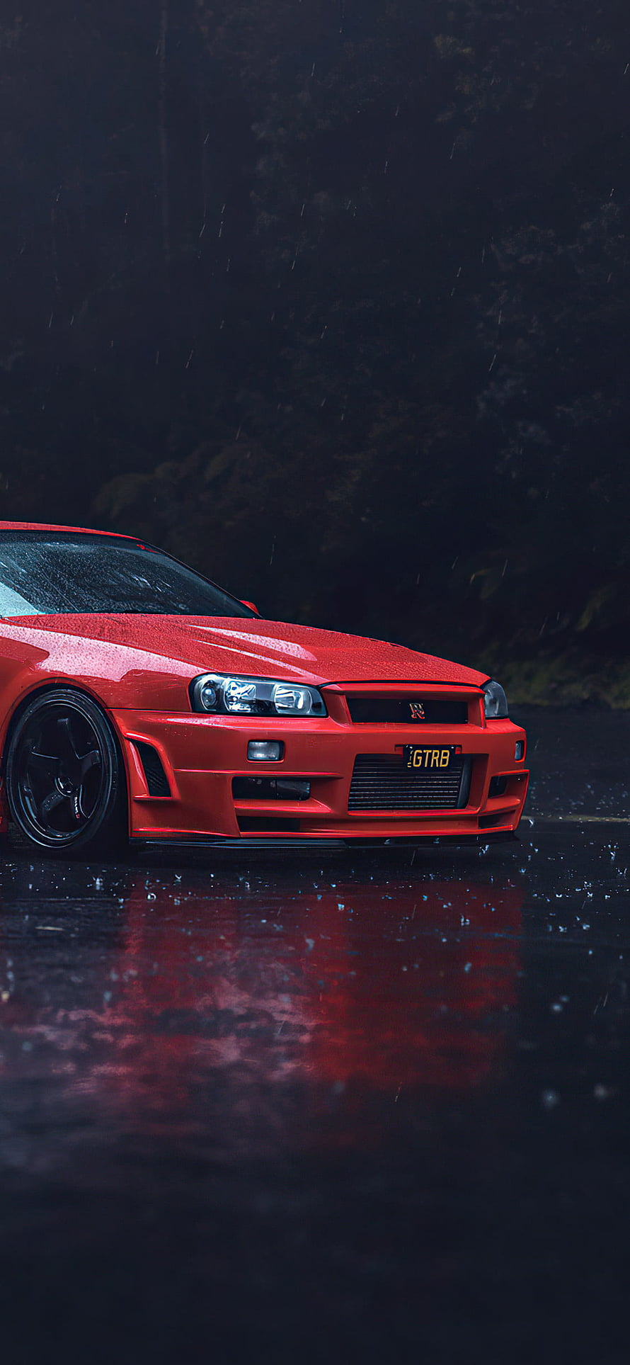 Red Nissan Skyline GT-R R34 parked on wet asphalt in the rain with dark forest background HD phone wallpaper