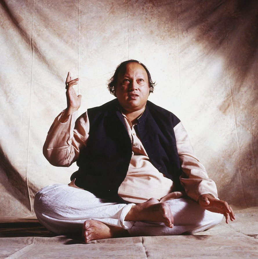 Nusrat Fateh Ali Khan seated in traditional attire performing expressive hand gestures HD phone wallpaper