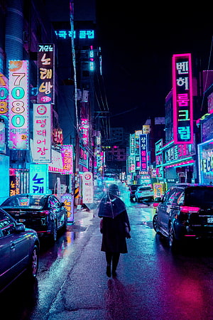 Lone figure with umbrella walking through rain-soaked Seoul street under vibrant neon signs at night HD phone wallpaper