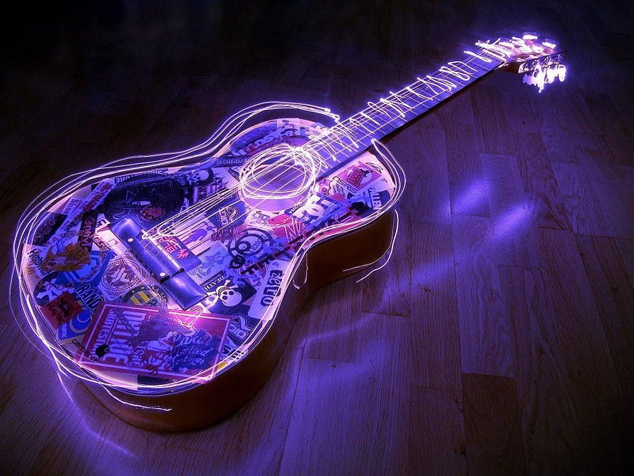 Glowing Neon Guitar Artwork with Sticker Collage on Wooden Floor HD wallpaper