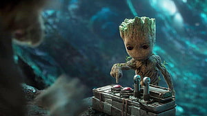 Baby Groot Pressing Buttons on a Sci-Fi Control Panel in a Dark Cavern HD wallpaper