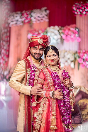 Traditional Indian Wedding Couple in Red and Gold Attire with Floral Decor HD phone wallpaper