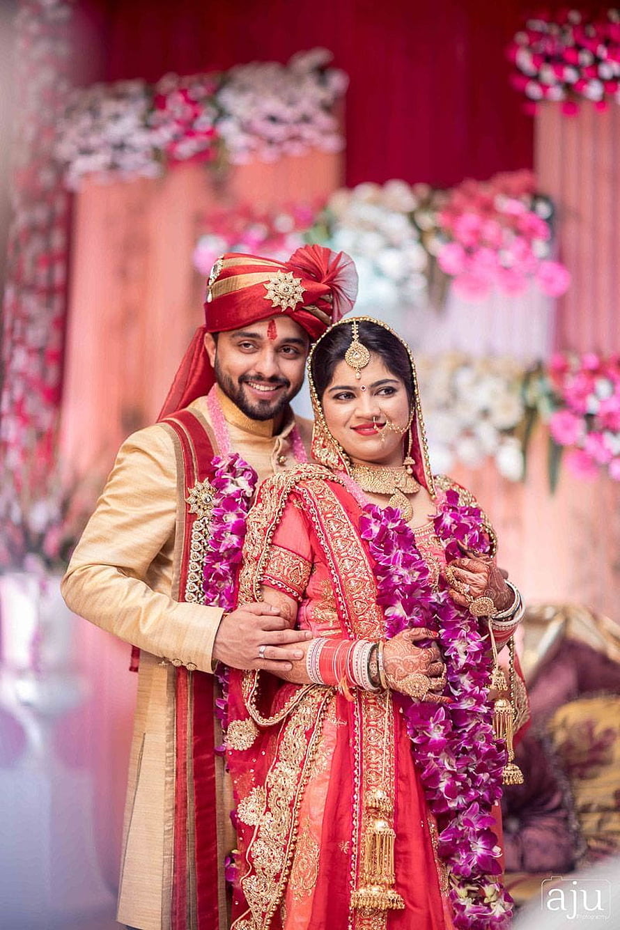 Traditional Indian Wedding Couple in Red and Gold Attire with Floral Decor HD phone wallpaper