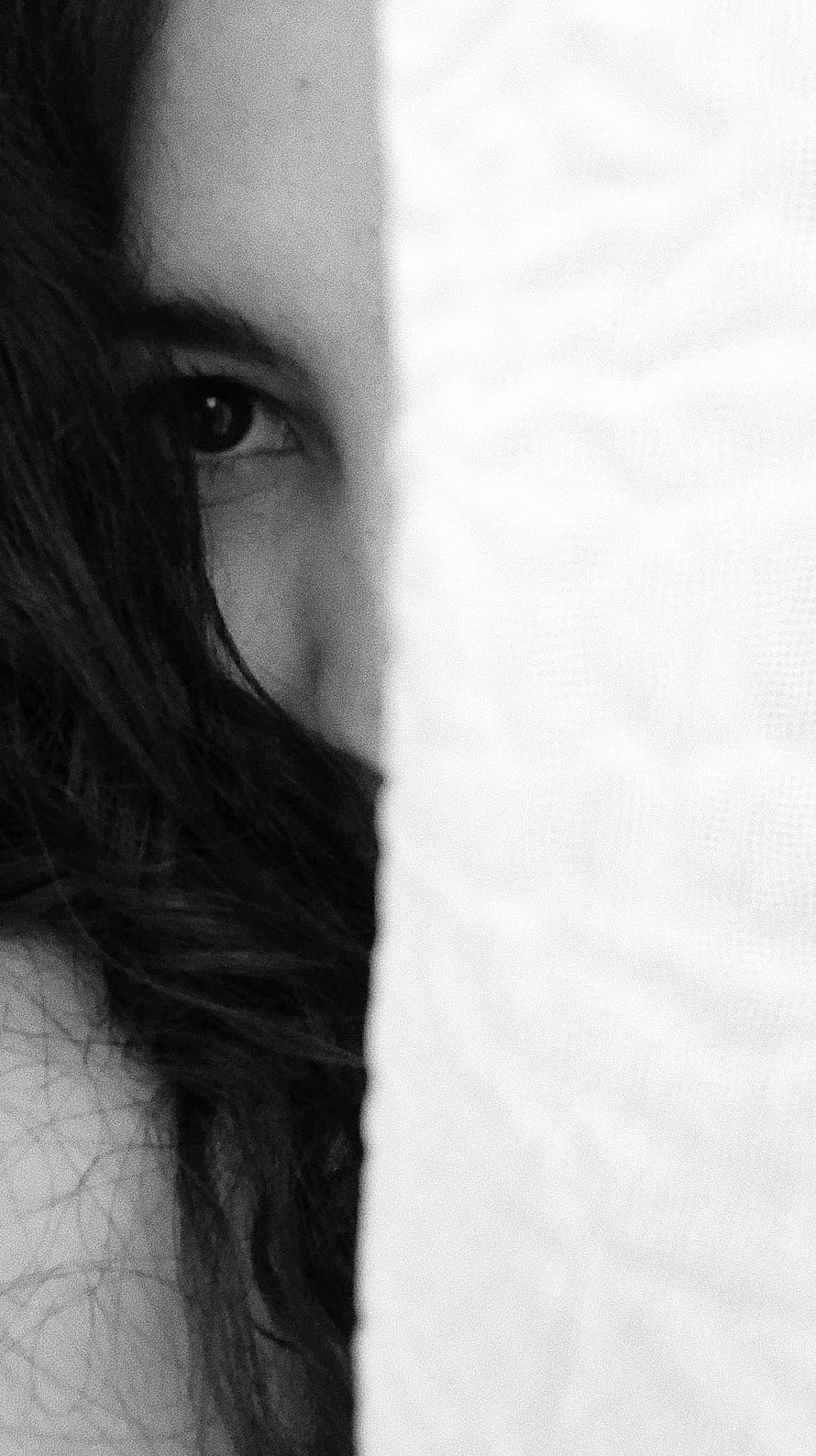 Black and White Portrait of a Woman Peeking From Behind a White Wall HD phone wallpaper