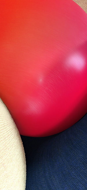 Vibrant Red Balloon Resting on Textured Fabric and Navy Blue Surface HD phone wallpaper