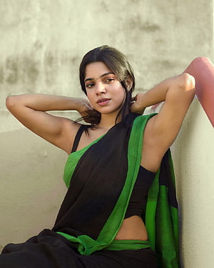 Divyabharathi in a Black and Green Saree Leaning Against a Wall HD phone wallpaper