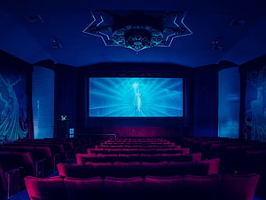 Cinematic Movie Theater Interior With Glowing Screen And Red Velvet Seating HD wallpaper