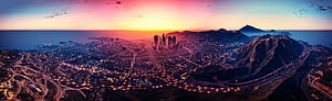 GTA V Los Santos Cityscape at Sunset with Vibrant Skyline and Coastal Mountains HD wallpaper