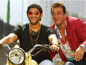 Munna Bhai M.B.B.S. promotional still featuring two men riding a motorcycle in a bright urban setting HD wallpaper