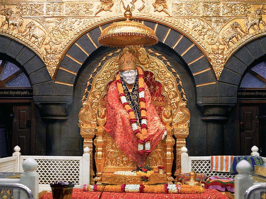 Sai Baba seated on ornate golden throne in temple shrine with red robes and flower garlands HD wallpaper