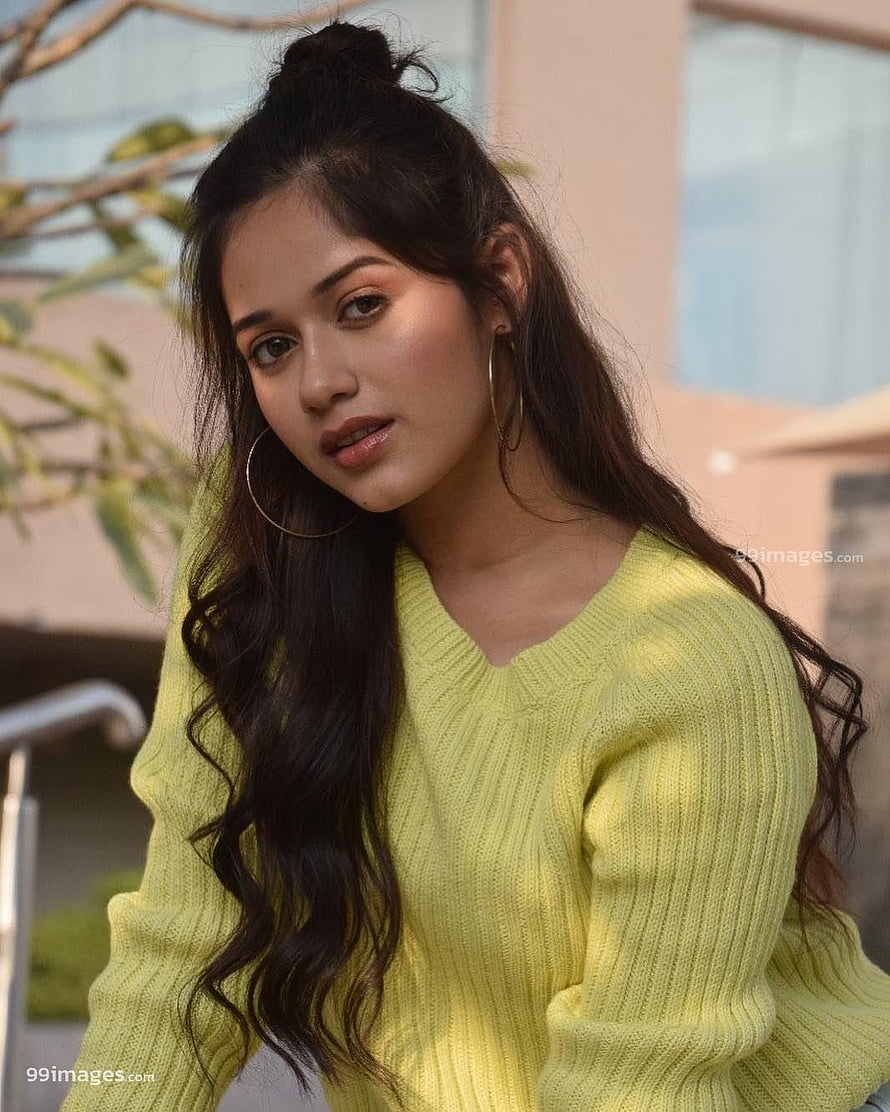 Jannat Zubair Rahmani in a soft yellow knit sweater with long wavy hair and hoop earrings HD phone wallpaper