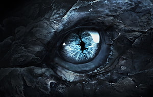 Glowing Dragon Eye in Dark Rock Cavern with Icy Blue Iris HD wallpaper
