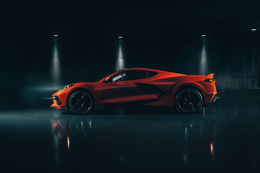 Chevrolet Corvette C8 Z06 in Vibrant Orange Under Dramatic Studio Lighting HD wallpaper