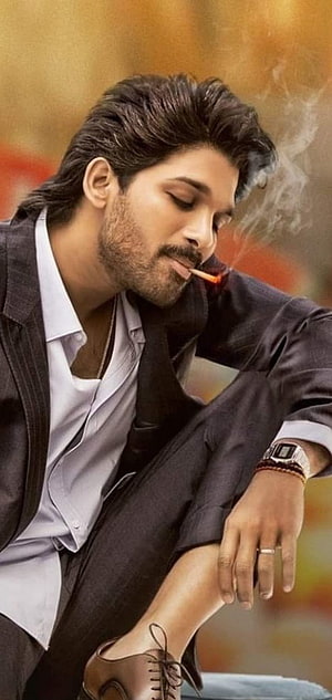 Allu Arjun in a dark suit smoking a cigarette with a warm autumn background HD phone wallpaper