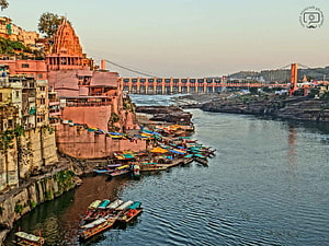 Omkareshwar Temple and River Narmada Ghat with Boats and Suspension Bridge at Dusk HD wallpaper
